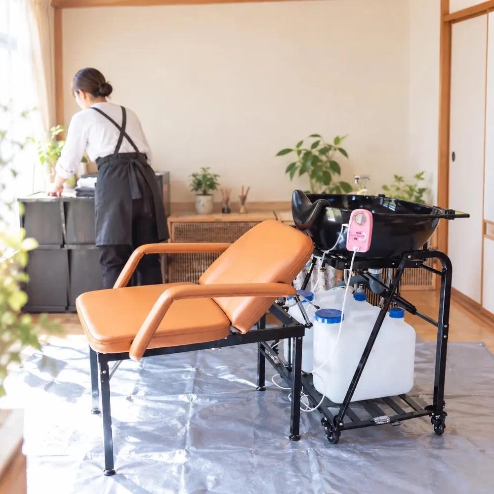 移動式シャンプー台を設置したお部屋と、準備をする美容師